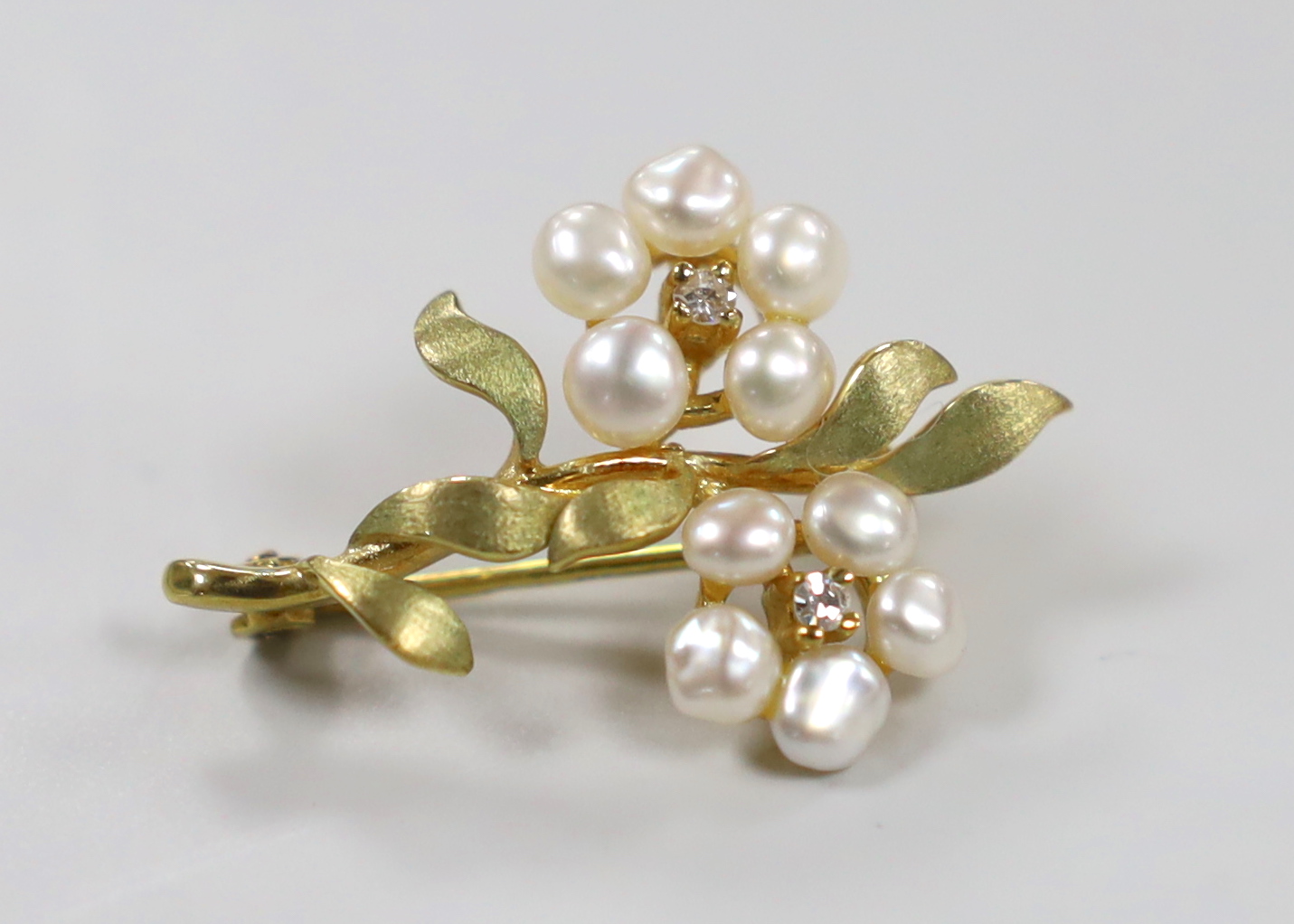 A modern 9ct gold, cultured pearl and diamond cluster set twin flower head brooch, 29mm, gross weight 3.1 grams.